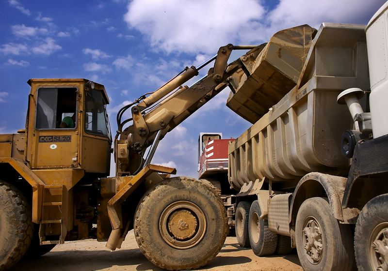 Loader placing storm debris into a dump truck
